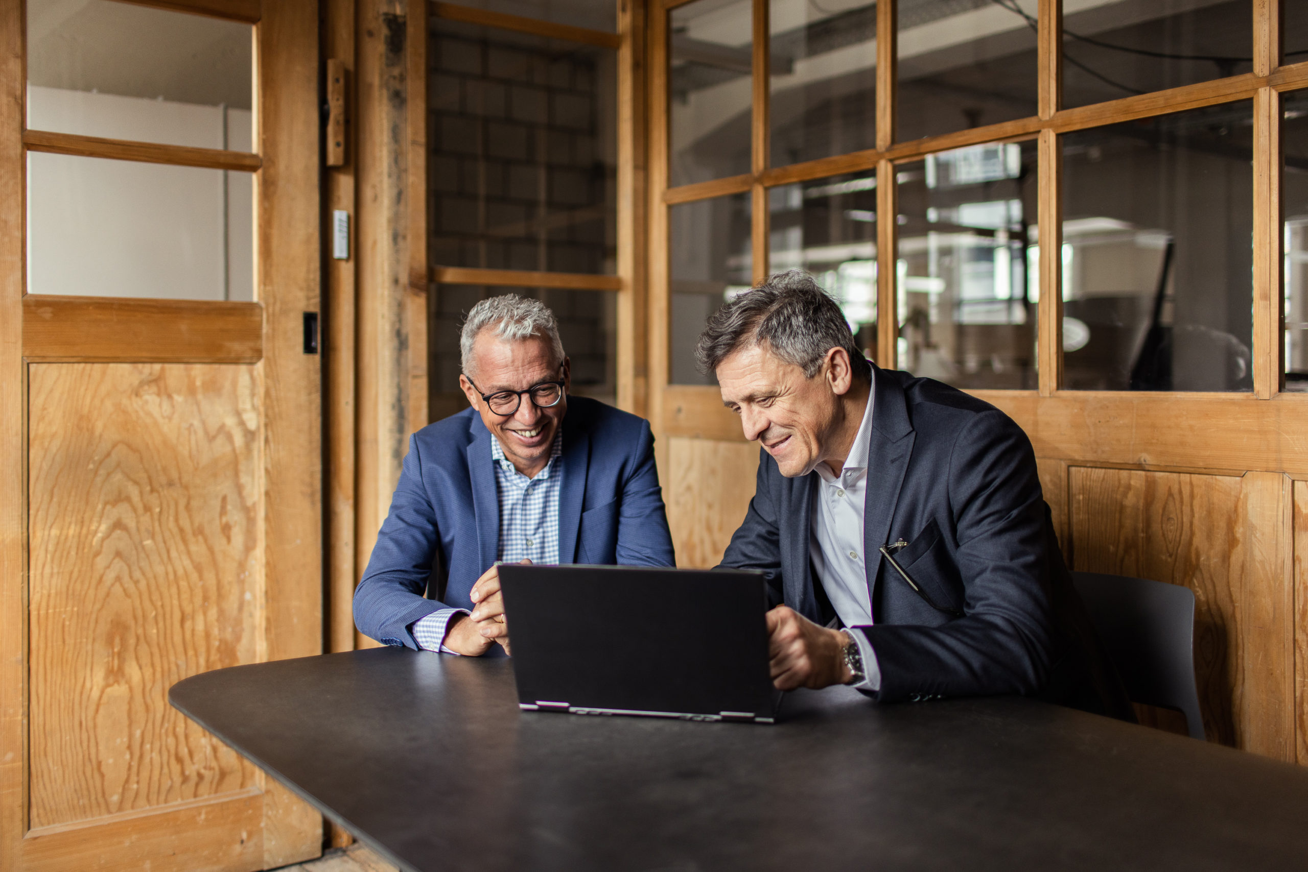 Edi Brandenberger und Andreas Choffat sitzen an einem Laptop und besprechen die Strategie für die Nachfolge eines Kunden